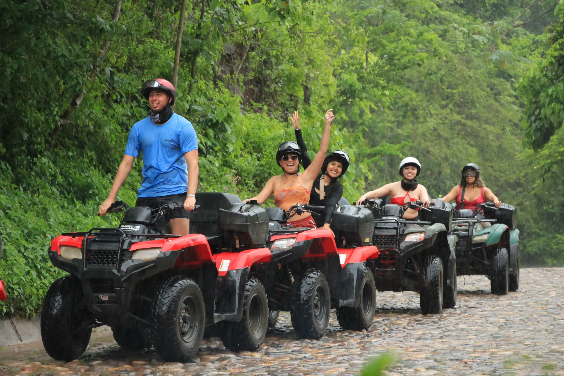 A group of Xiutla Riders EcoAdventures enjoying an exhilarating ATV ride on a cobblestone road