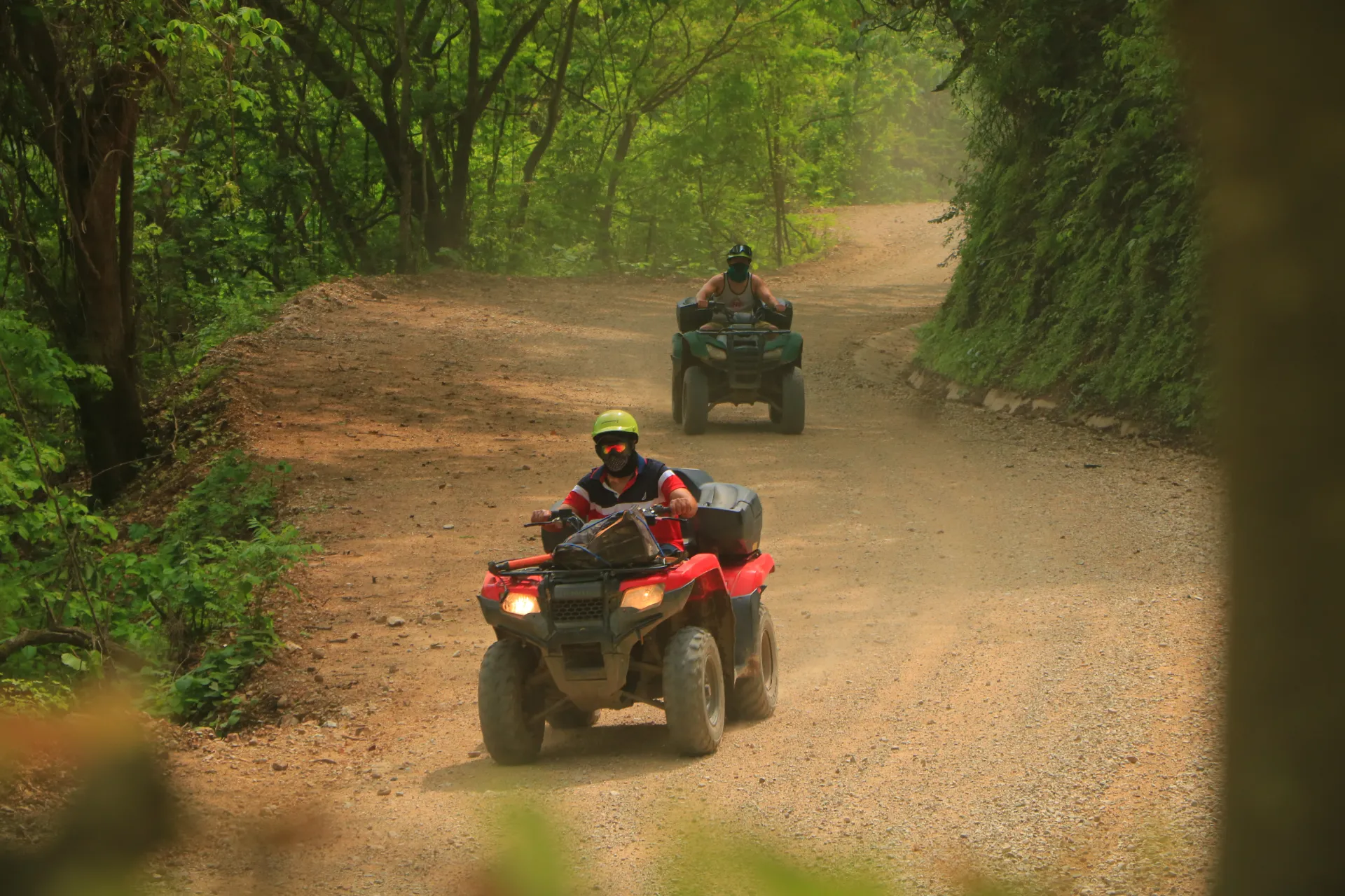 A group of people enjoying an exhilarating ATV tour down a dirt road in Puerto Vallarta