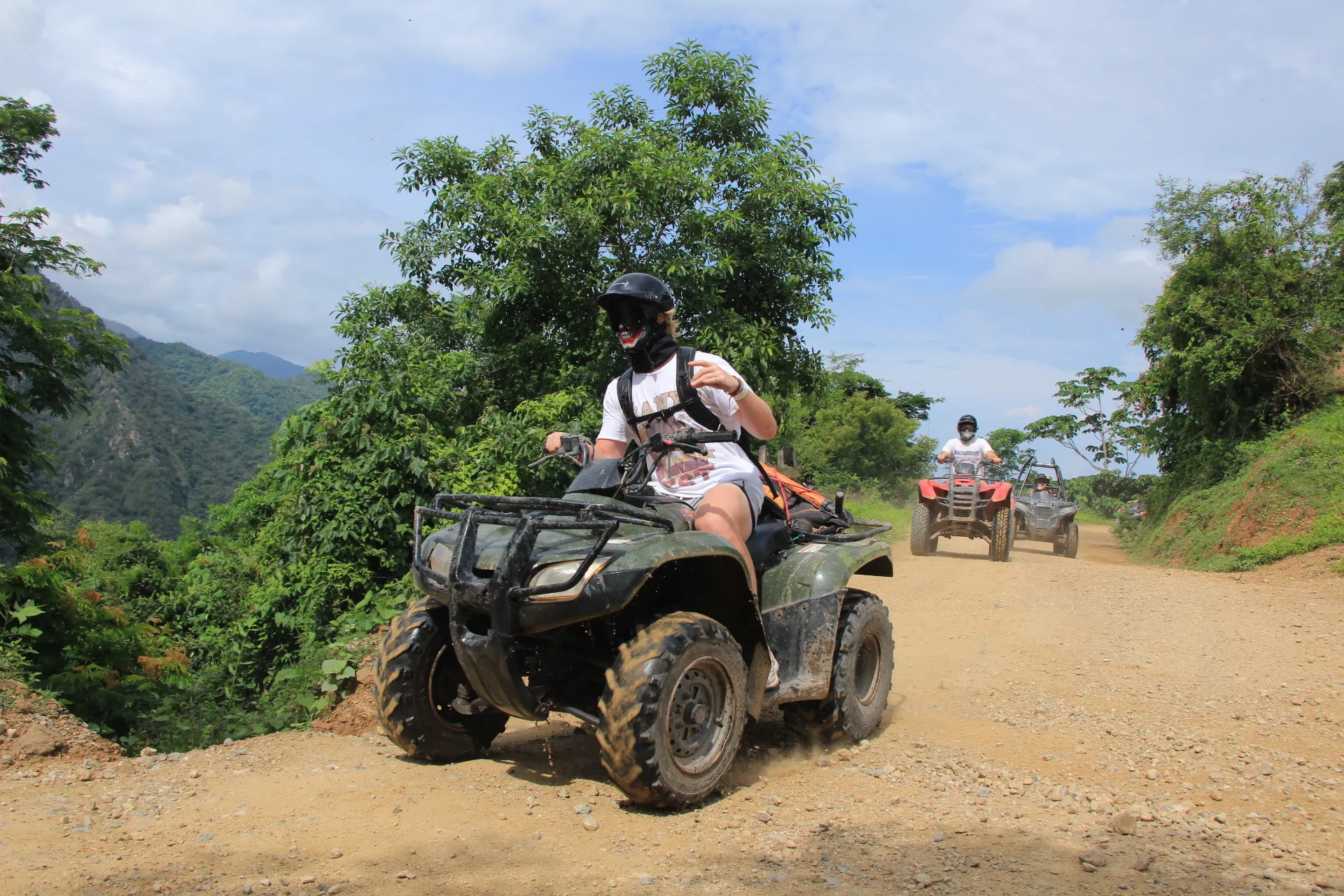 A group from Xiutla Riders EcoAdventures taking ATV Tours down a dirt road