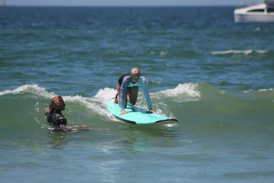 A woman is riding a surfboard in the ocean during an Private Surf Lessons provided by Xiutla Riders EcoAdventures.